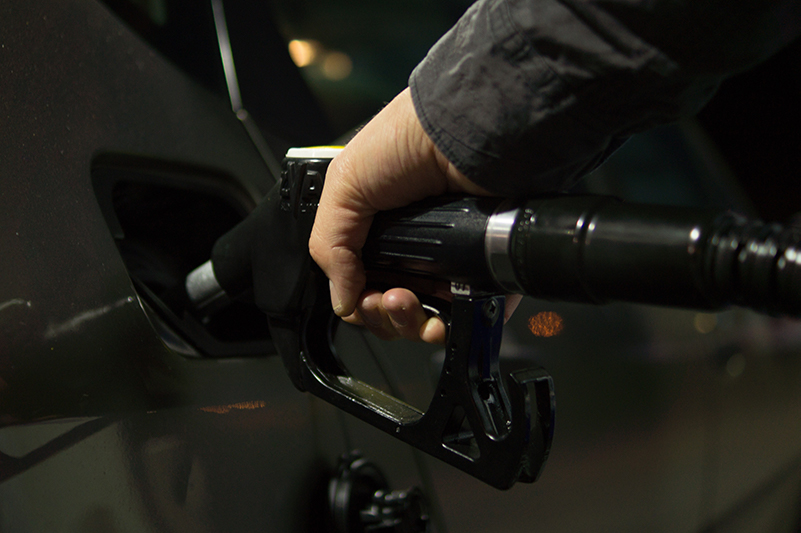 A hand of a person filling up a car with gas.